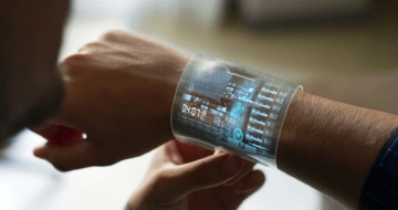 Futuristic transparent smartwatch showing digital data and a timer on a person's wrist.