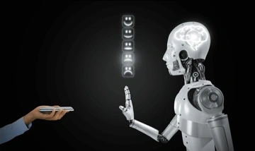 A humanoid robot with a transparent head showing a brain interacts with a human hand holding a smartphone, with emoticon symbols above indicating emotions.